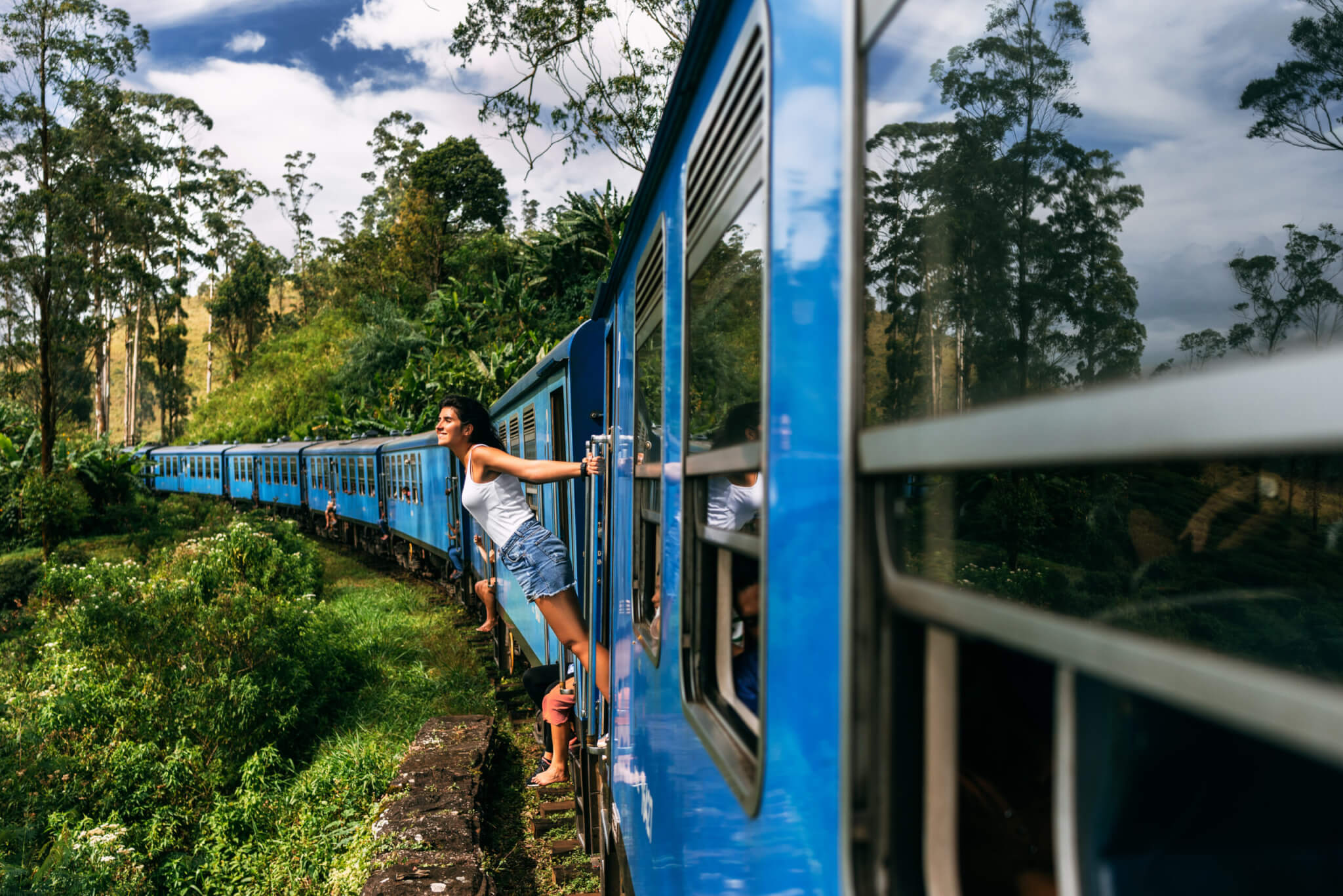 The girl travels by train to beautiful places. Beautiful girl traveling by train among mountains. Travel by train. Travelling to Asia. Trains Sri Lanka. Railway transport. Railway. Transport Asia