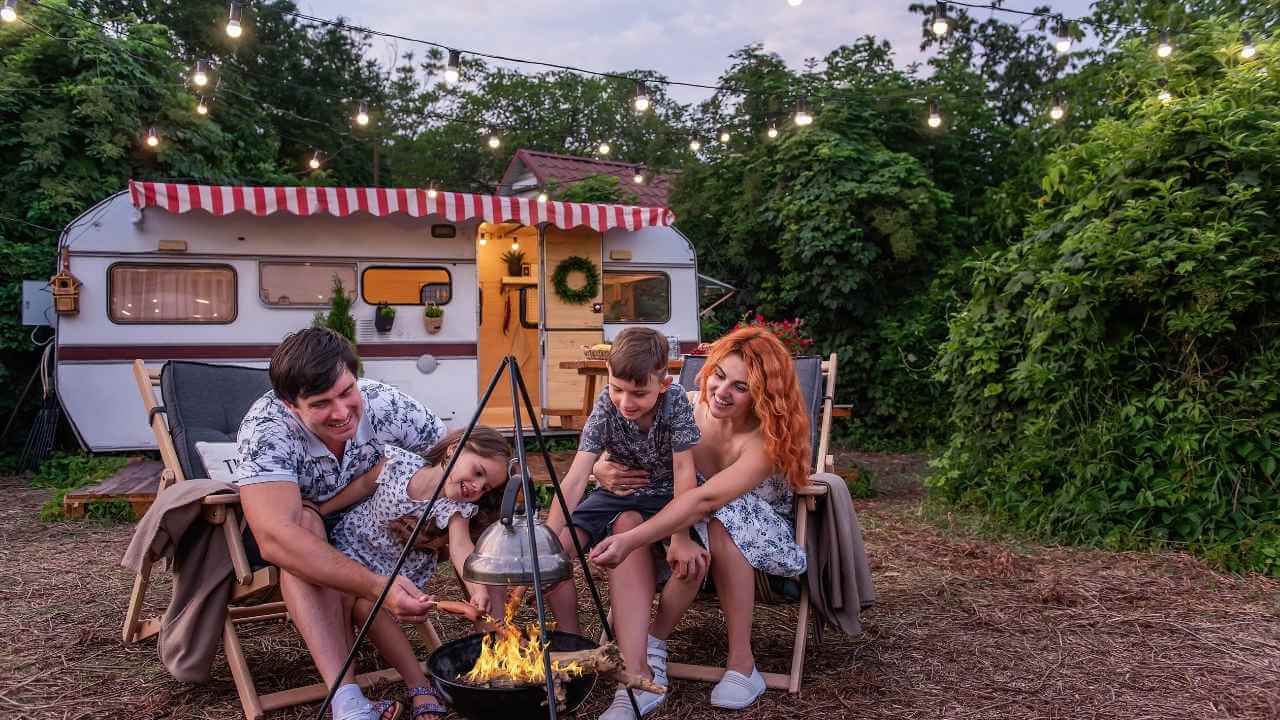 a family sitting around a campfire in front of an rv