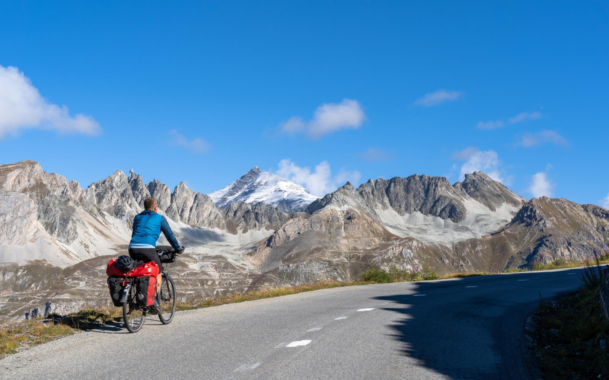 A cyclist riding on the Col d'Iseran, a high mountain pass in the Savoie department of France. The Col d'Iseran is part of the Grande Route des Grandes Alpes,
