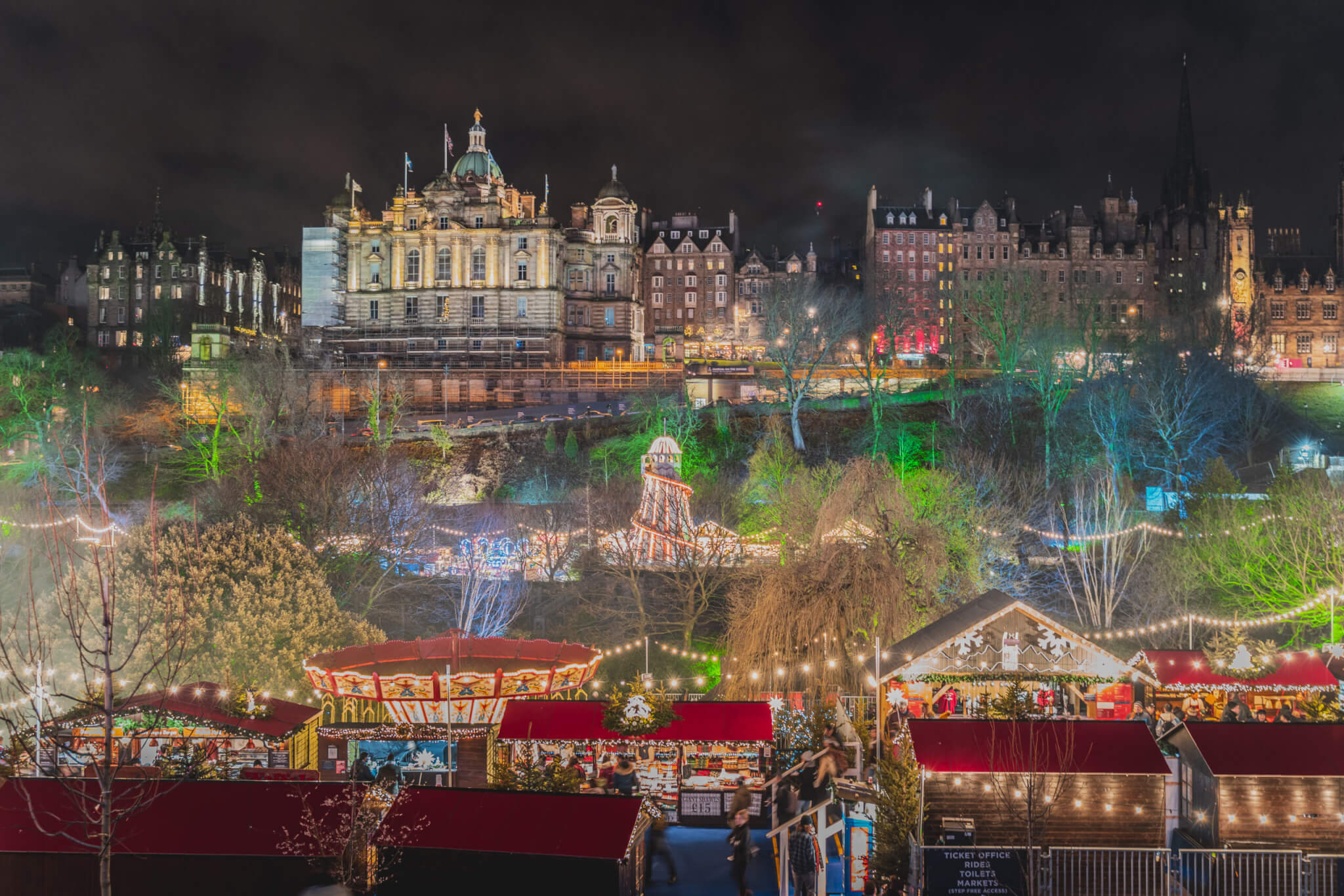 Christmas Market at Edinburgh, Scotland. Night lights lit up setting a lovely scene against the night sky.