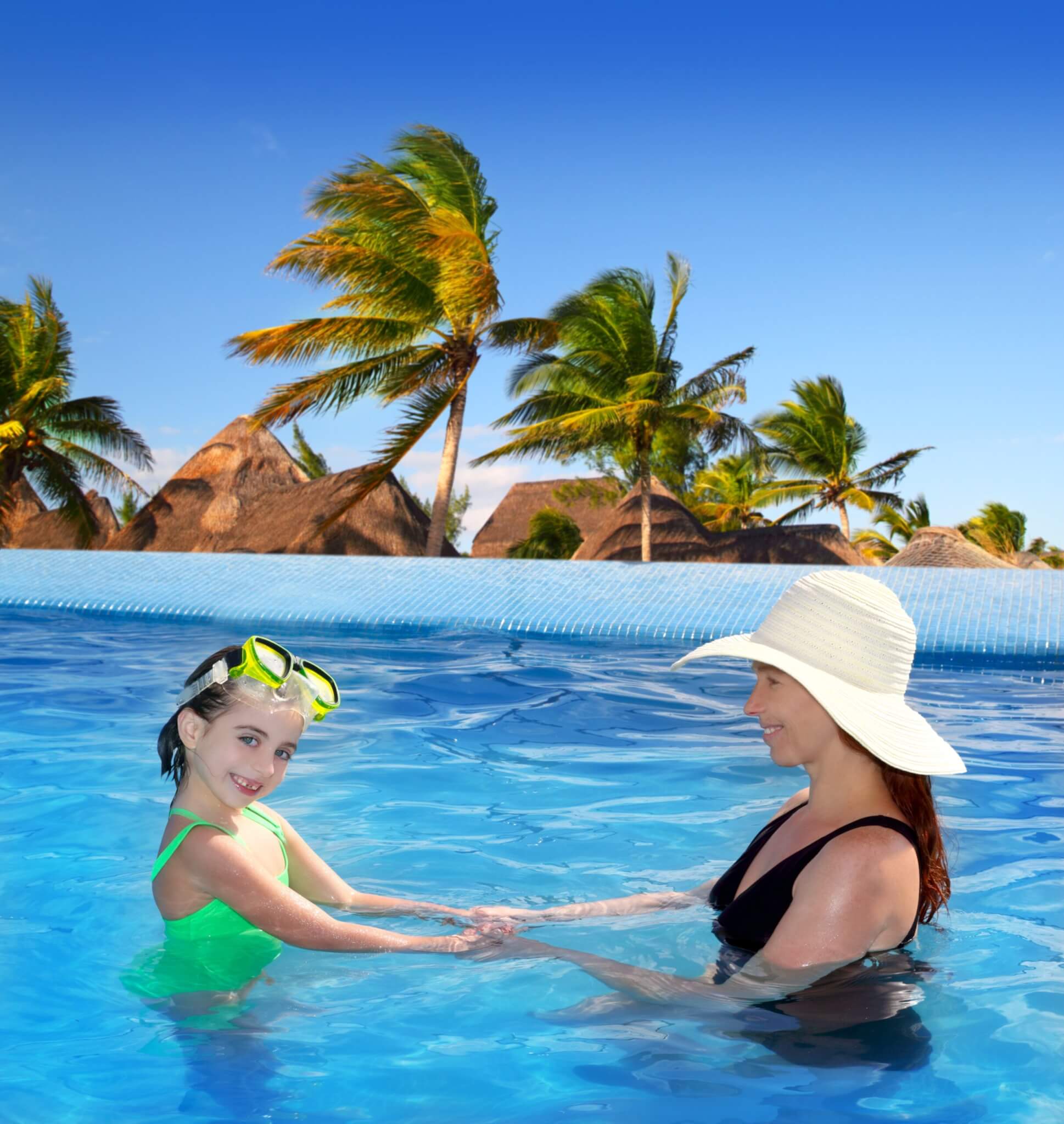 daughter and mother in swimming pool tropical