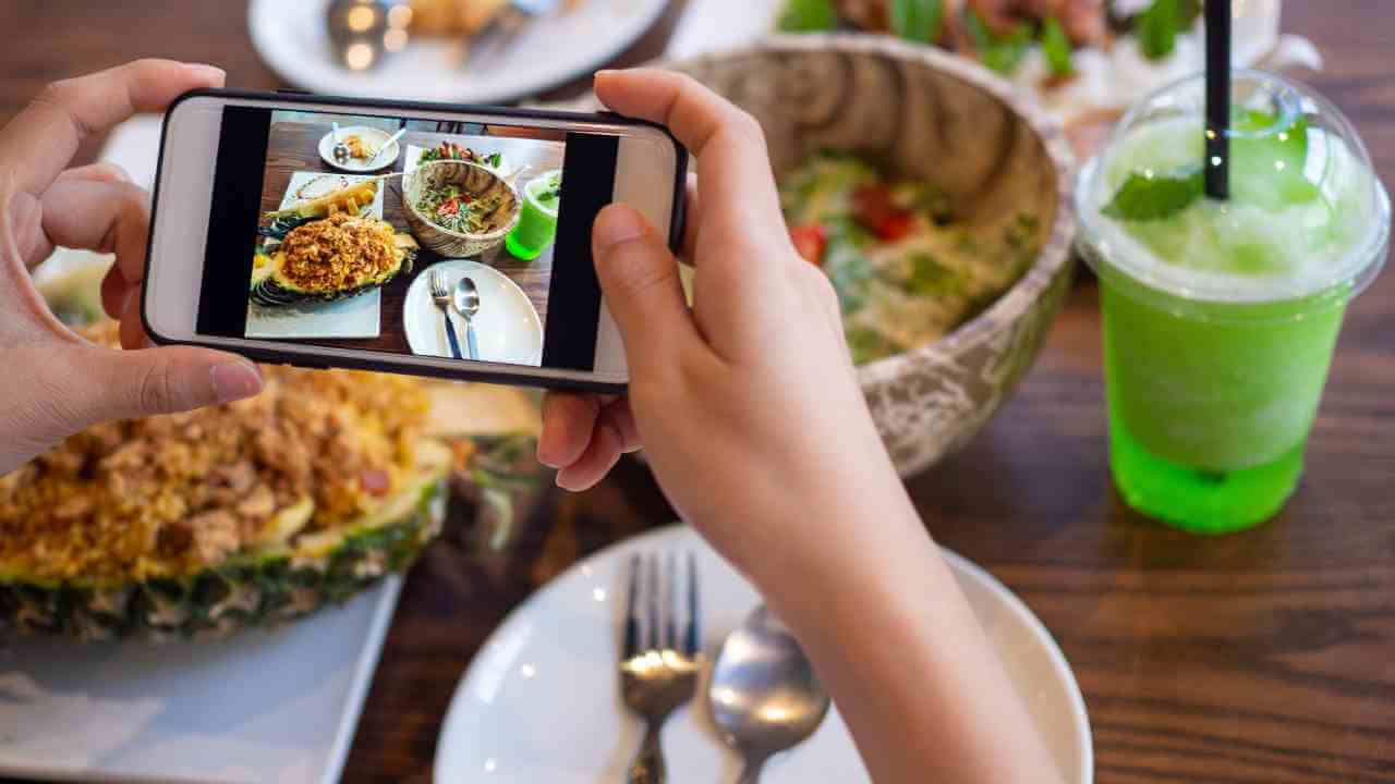 a person taking a photo of food on a table