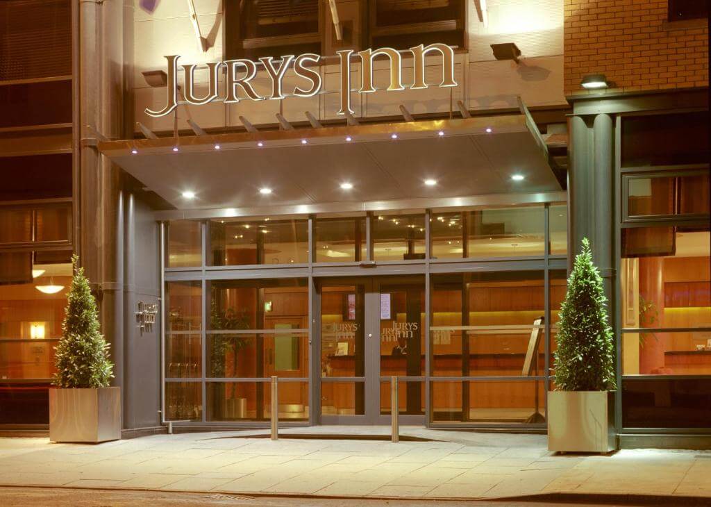 Exterior image of the Jurys Inn hotel in Dublin at night time all lit up 