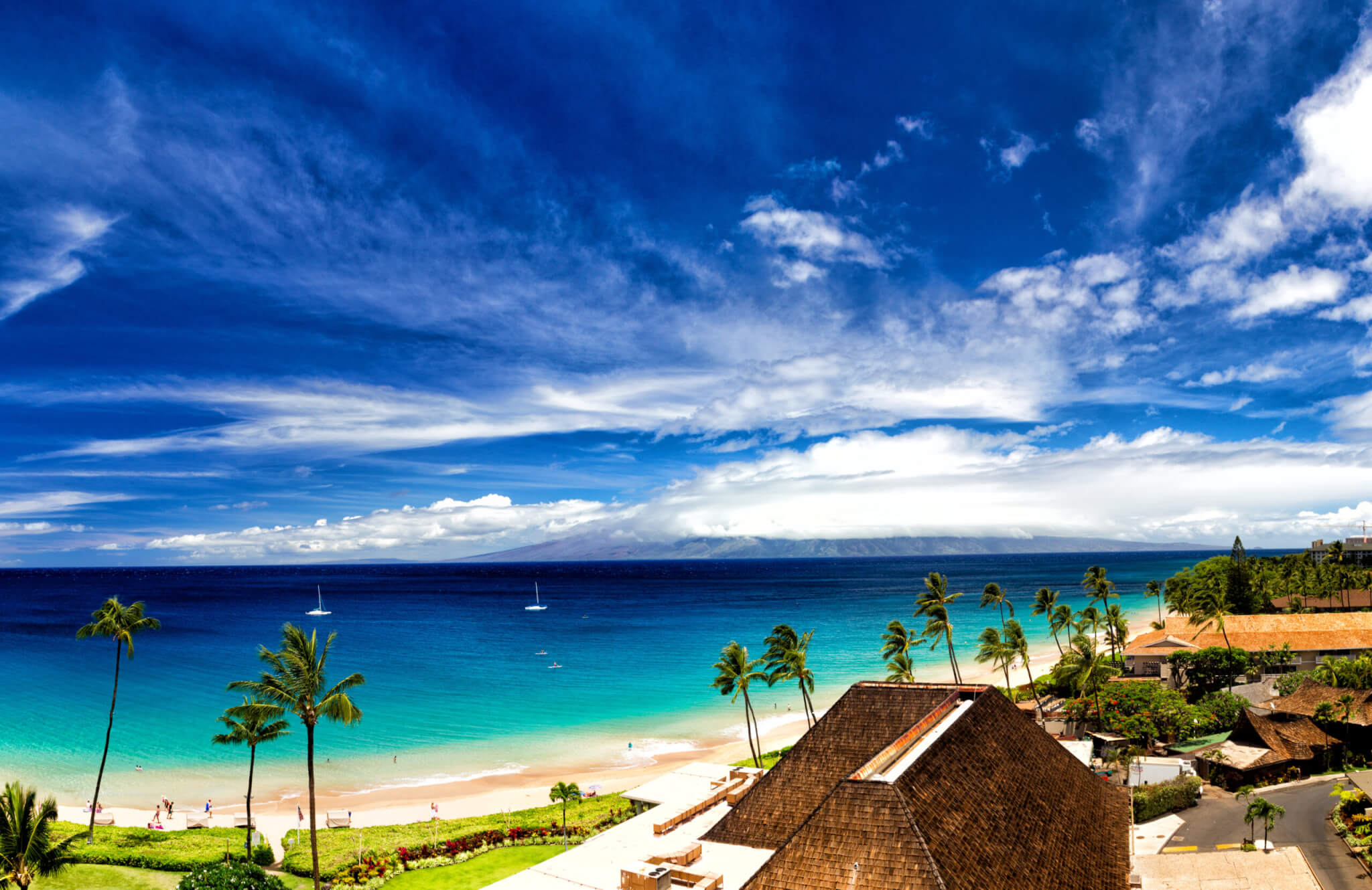 Blick über den Strand von Kaanapali Beach auf Maui über das Meer auf die Insel Molokai in Hawaii, USA.