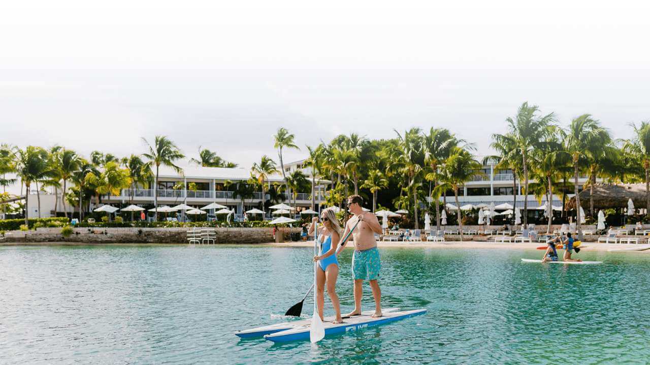 couple paddle boarding outside of hawks cay resort