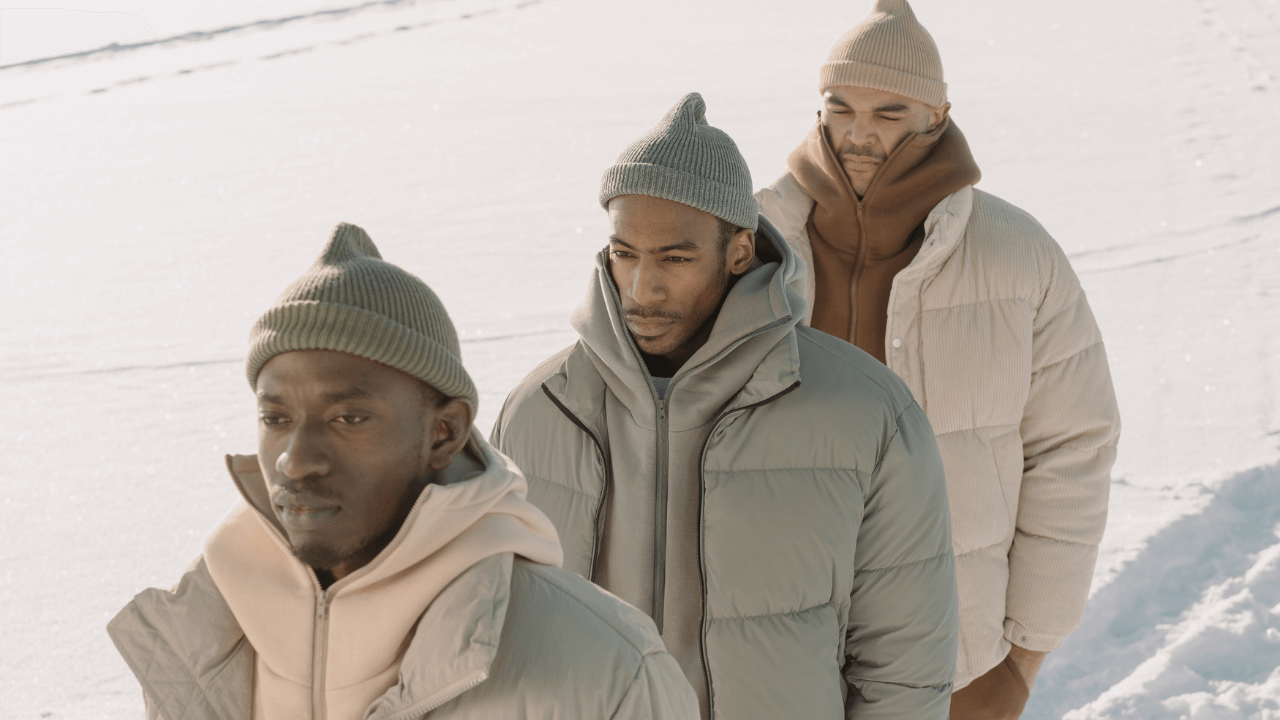 three men wearing outwear jackets in the winter time 