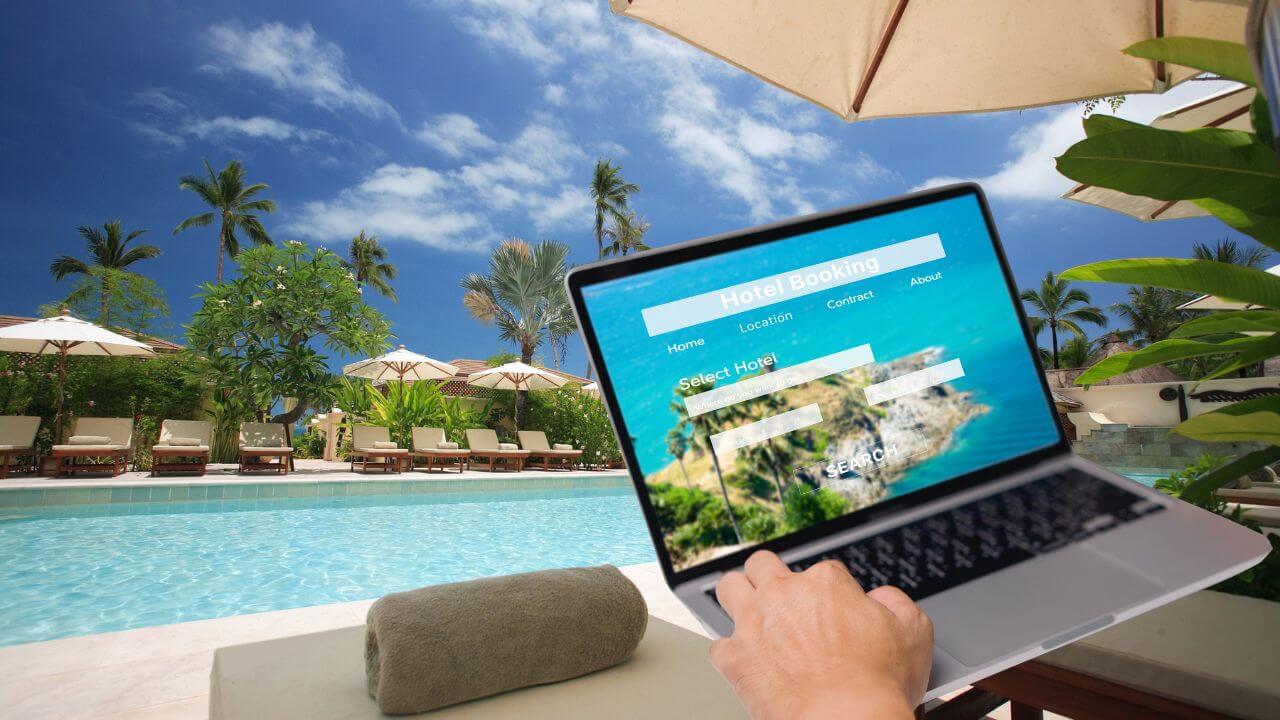 person booking hotel online with the hotel pool in the background