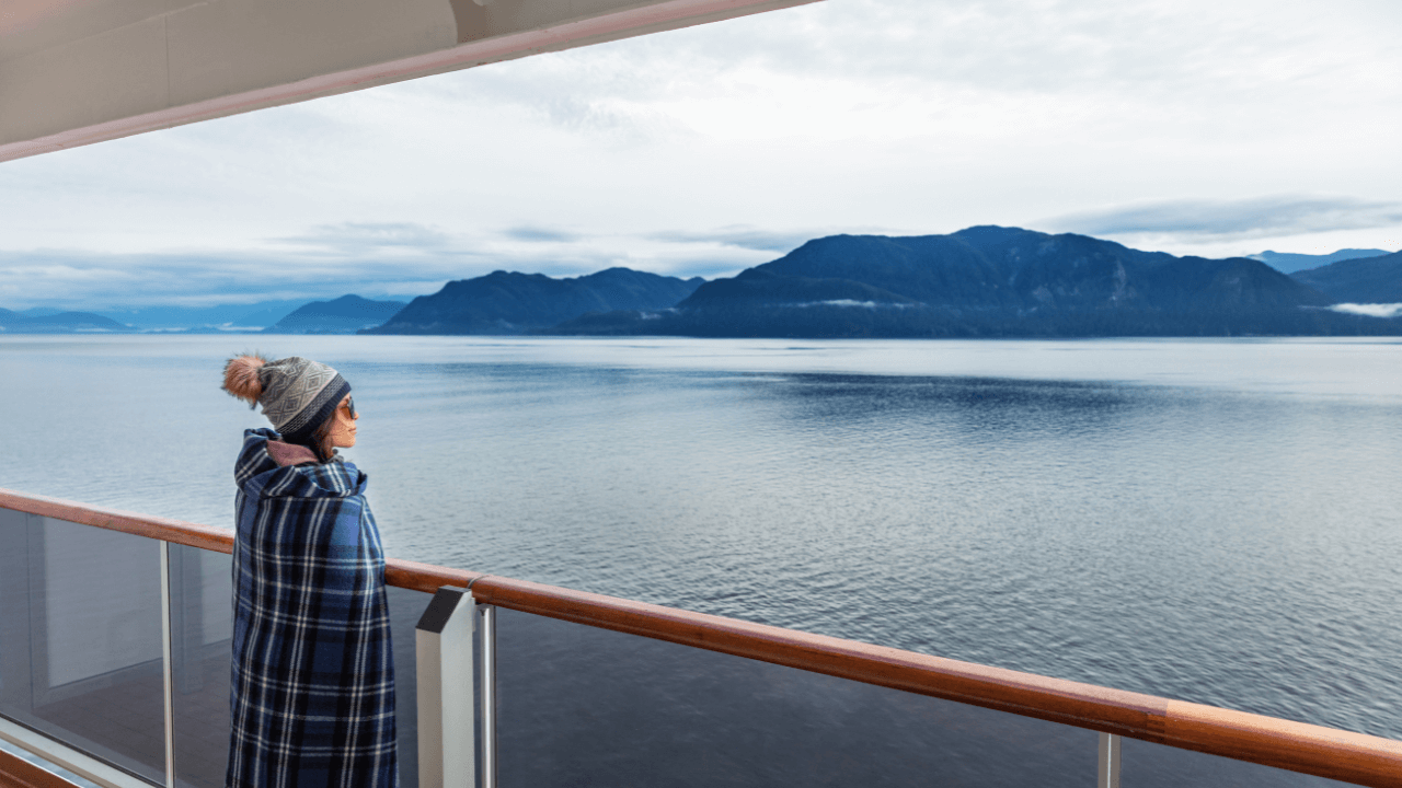 lady looking off of cruise ship balcony at the alaska