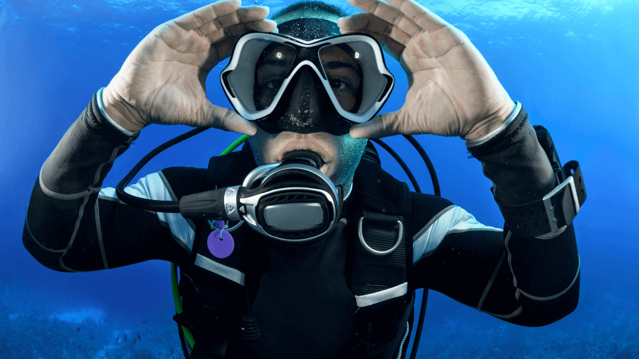 scuba diver showing off their gear in the ocean
