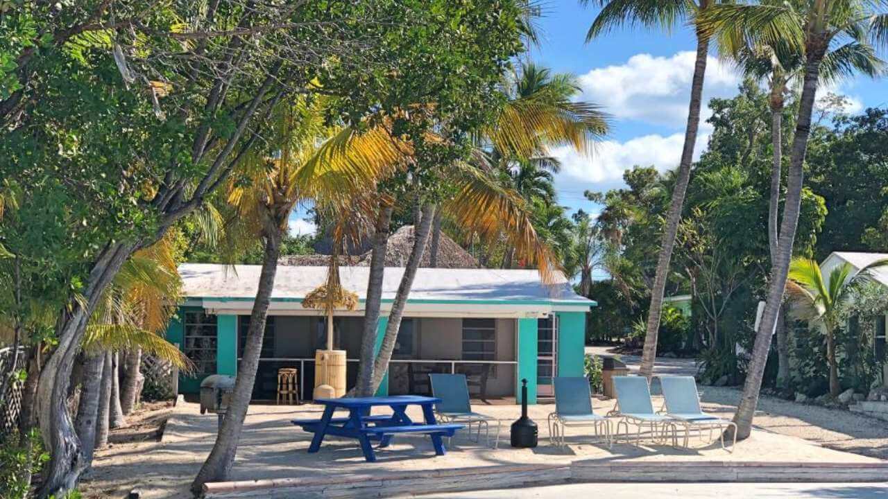 blue key largo cottage with beach chairs and picnic table outside