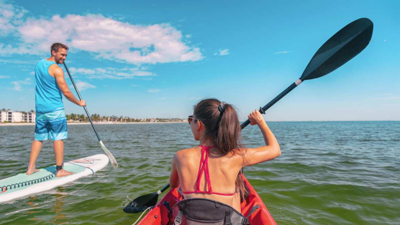 male and woman paddle boarding and kyaking in the florida keys