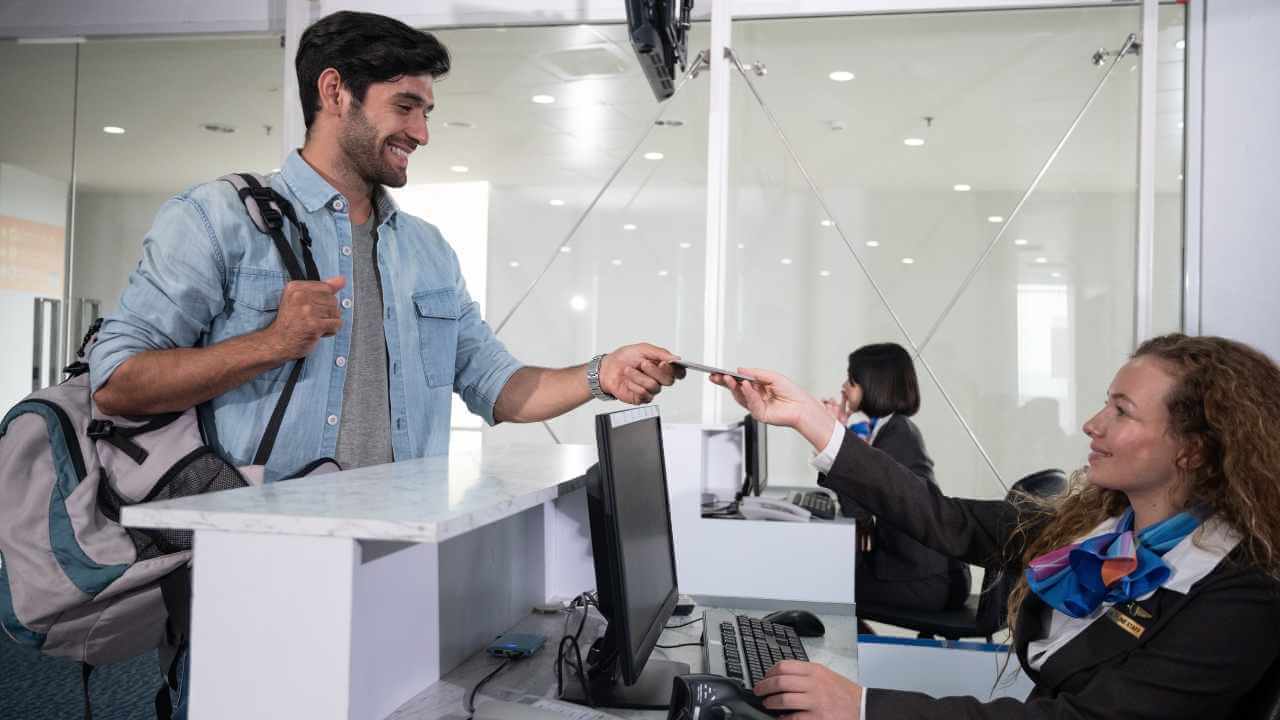 person handing card to flight attendant 