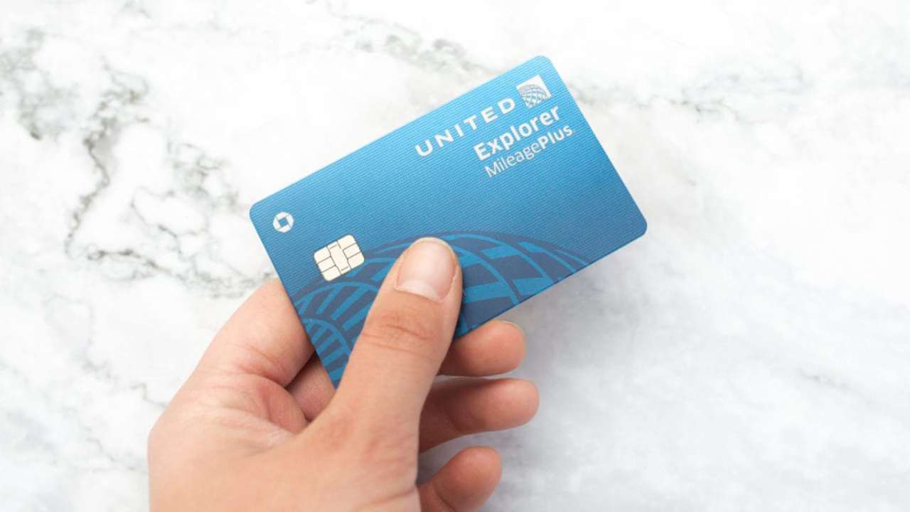 persons hand holding the united credit card