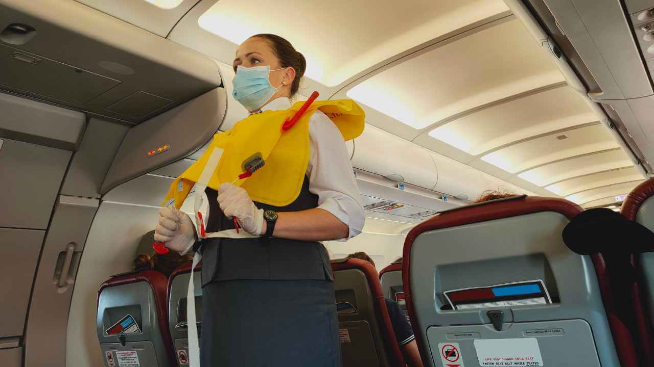 flight attendant performing safety speech on airplane