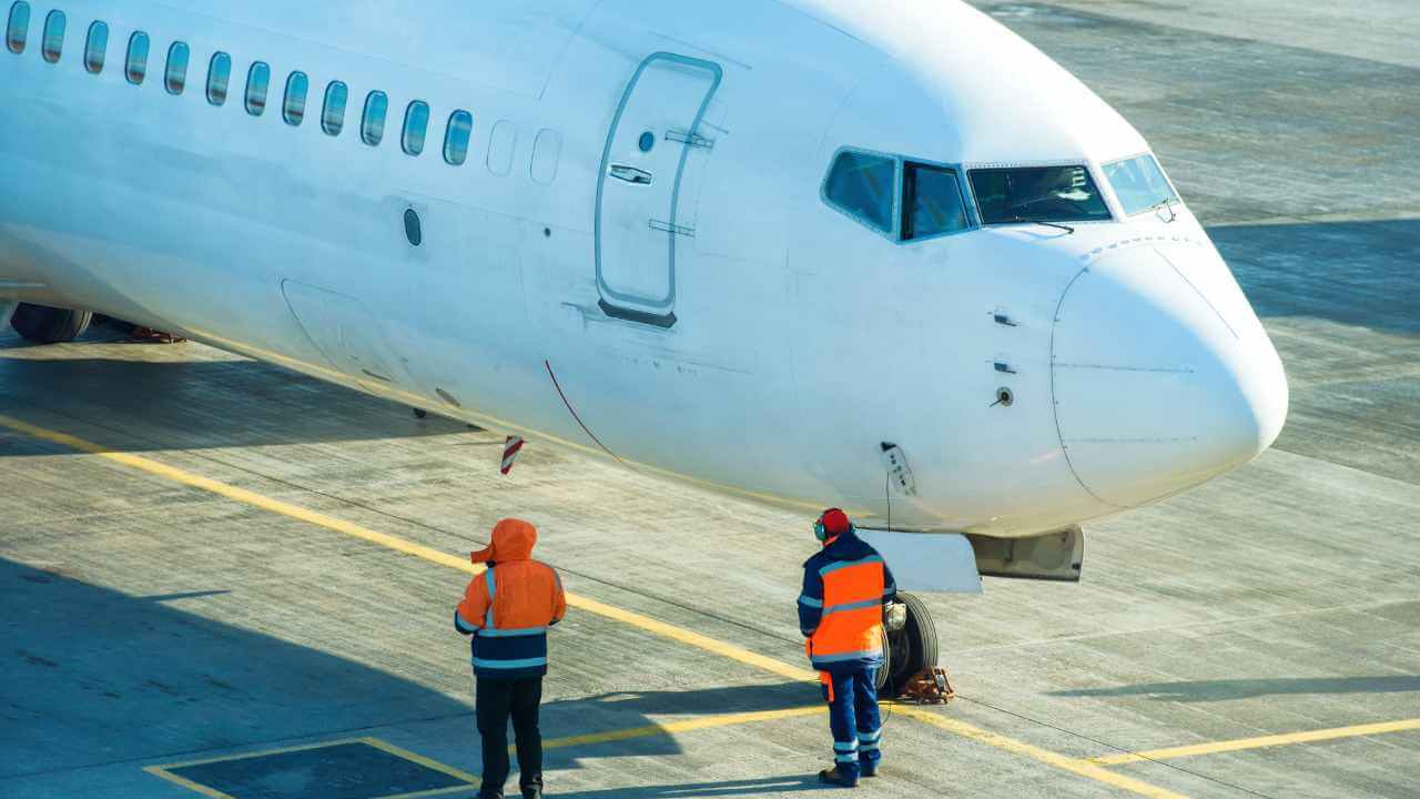 airport attendant guiding plane out of airport