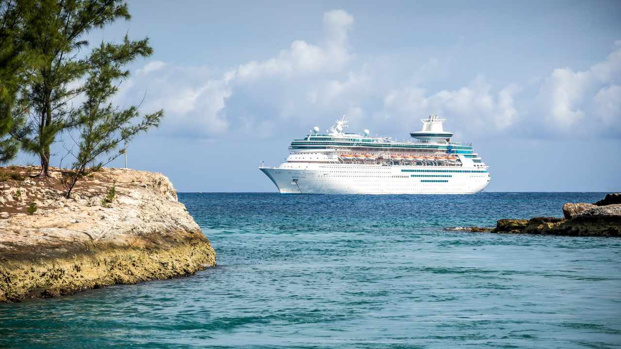 cruise ship sailing to a tropical island