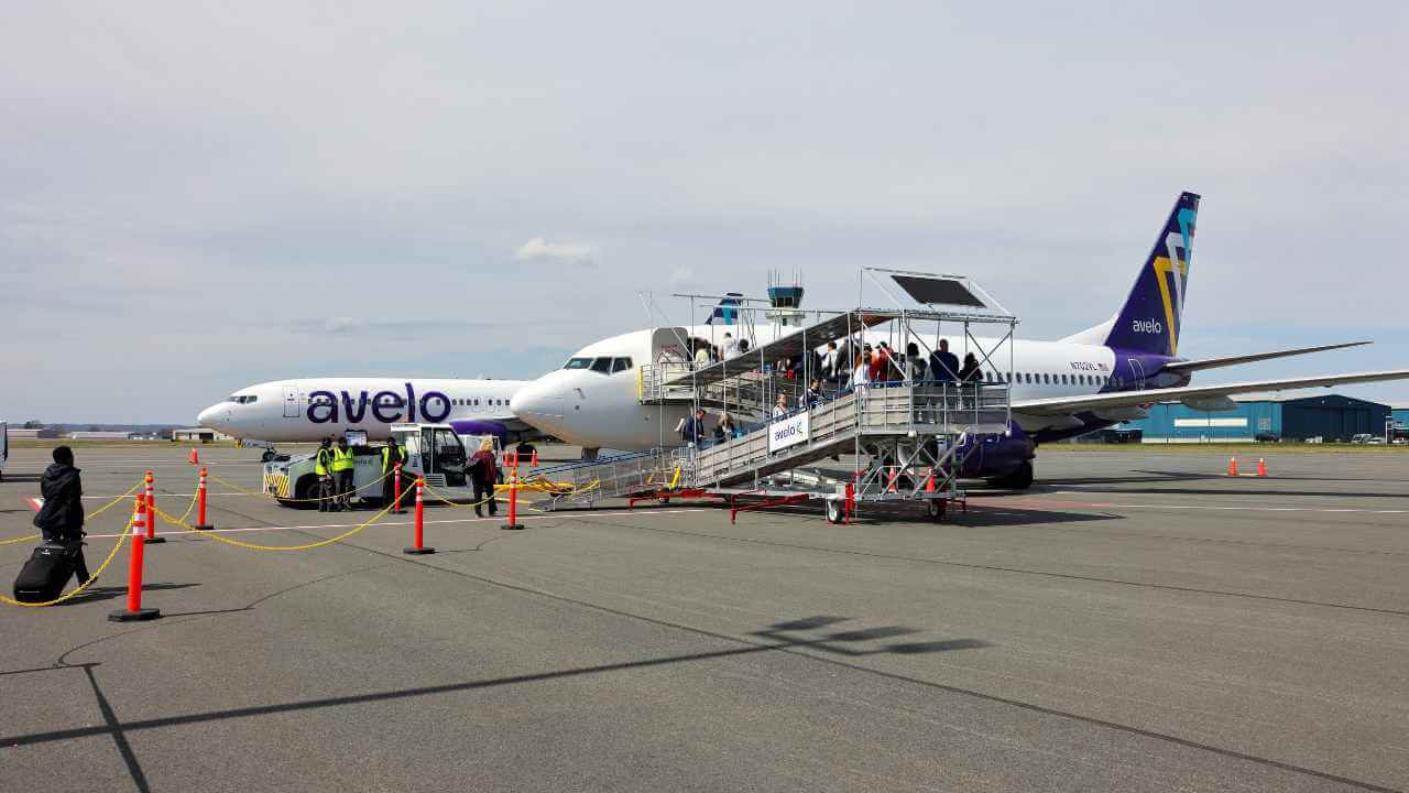 avelo airline passenger getting on plane on tarmac