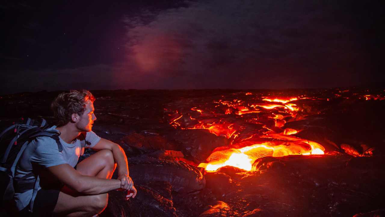 backpacker next to lava from volcanos in hawaii