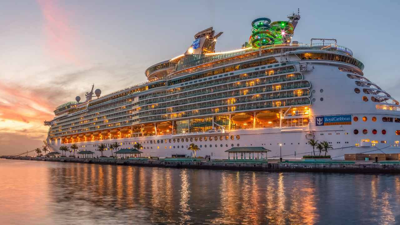 royal caribbean cruise ship lit up at night docked a caribbean port