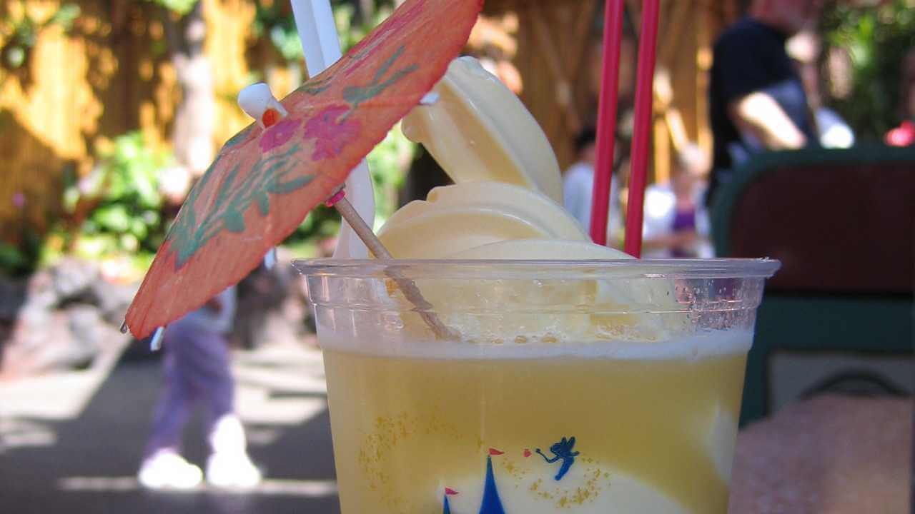 pineapple juice and pineapple dole whip in a drink with a mini umbrella as a garnish