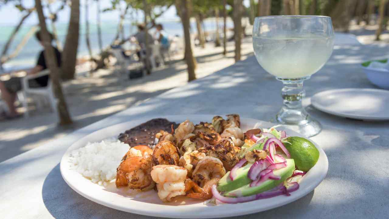 plate of mexican food and margarita at tulum beach 