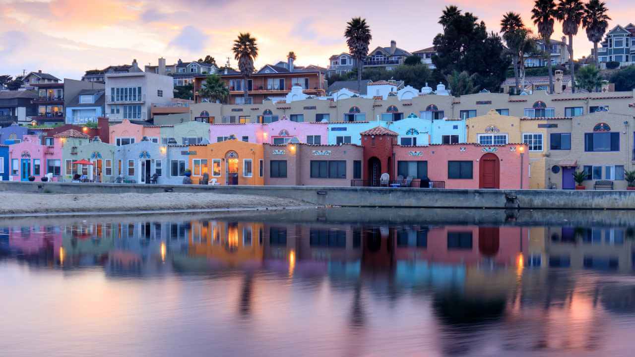 colorful houses line the shore of a body of water