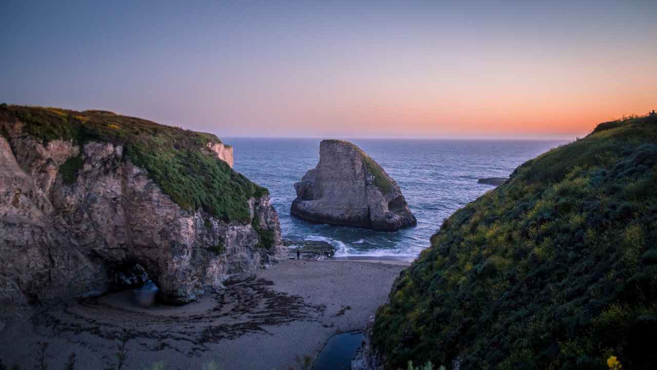 view of shark cove at sunset, rock formation that looks like shark fin