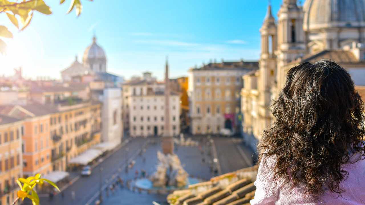 woman looking out towards the city of rome from her hotel balcony