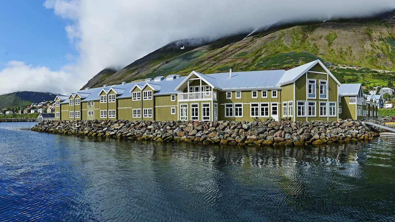 view of the green siglo hotel on the water in iceland