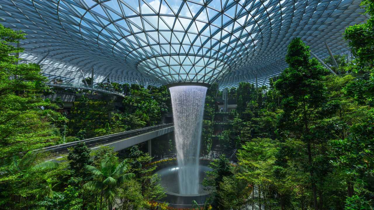 an indoor waterfall in the middle of a tropical forest