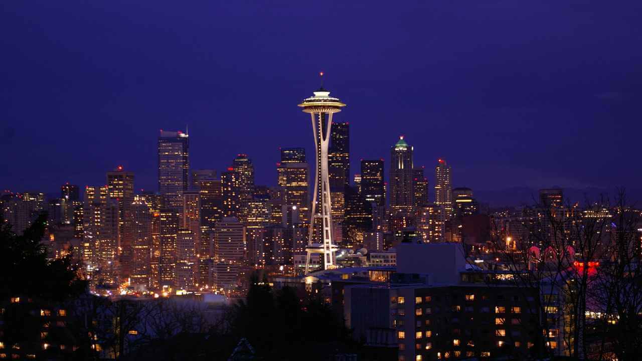 the seattle skyline at night with the space needle in the foreground