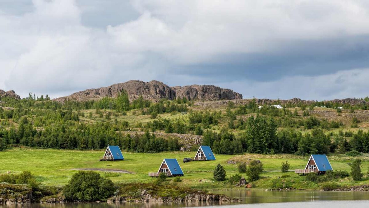 egilsstadir, iceland cottages or cabins by fellabaer city and river on ring road with traditional hut architecture, blue roofs for camping