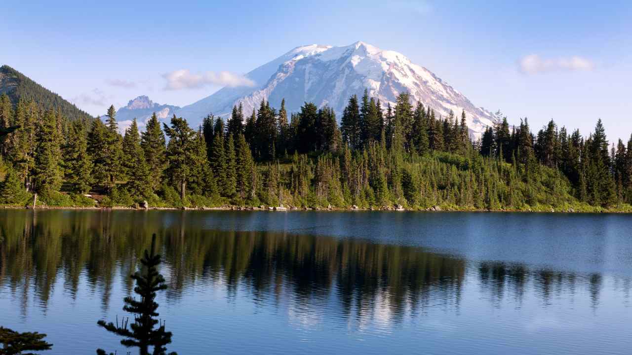 a mountain is reflected in a lake surrounded by trees
