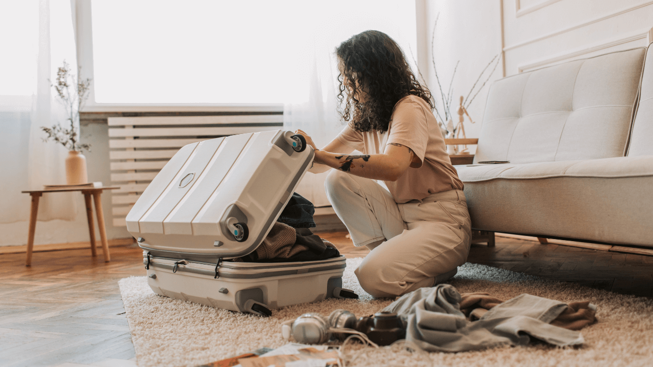 girl packing a suitcase on the floor