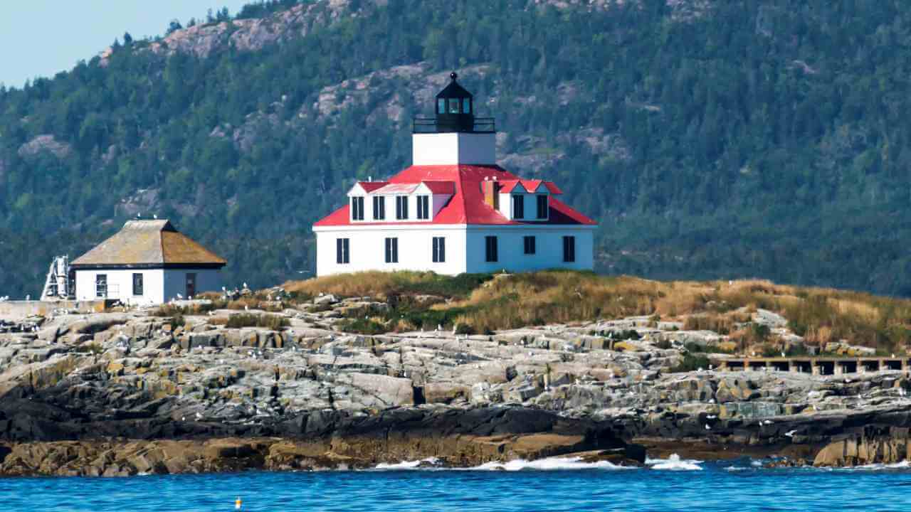 a lighthouse sits on top of a rocky island