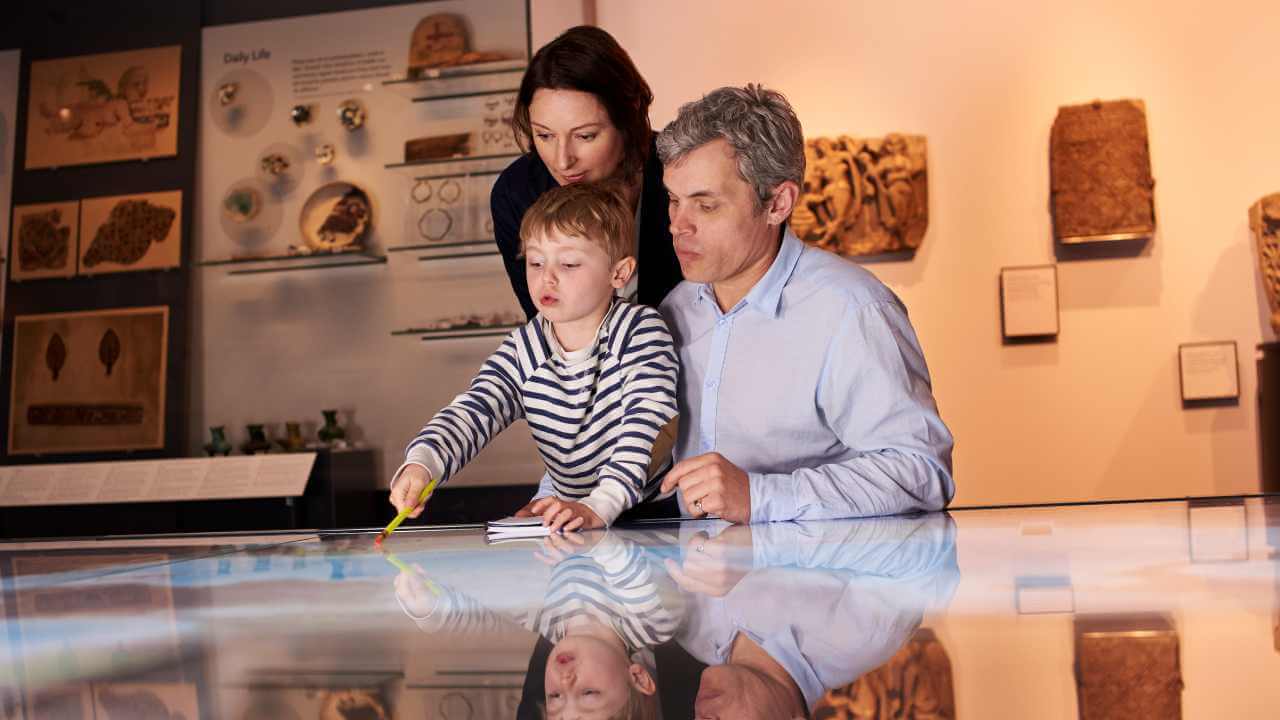 A family is looking at an interactive display in a museum