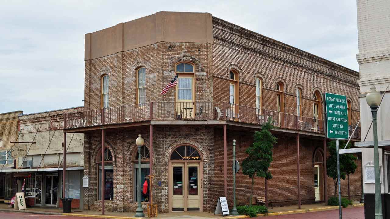 an old brick building sits on the corner of a street