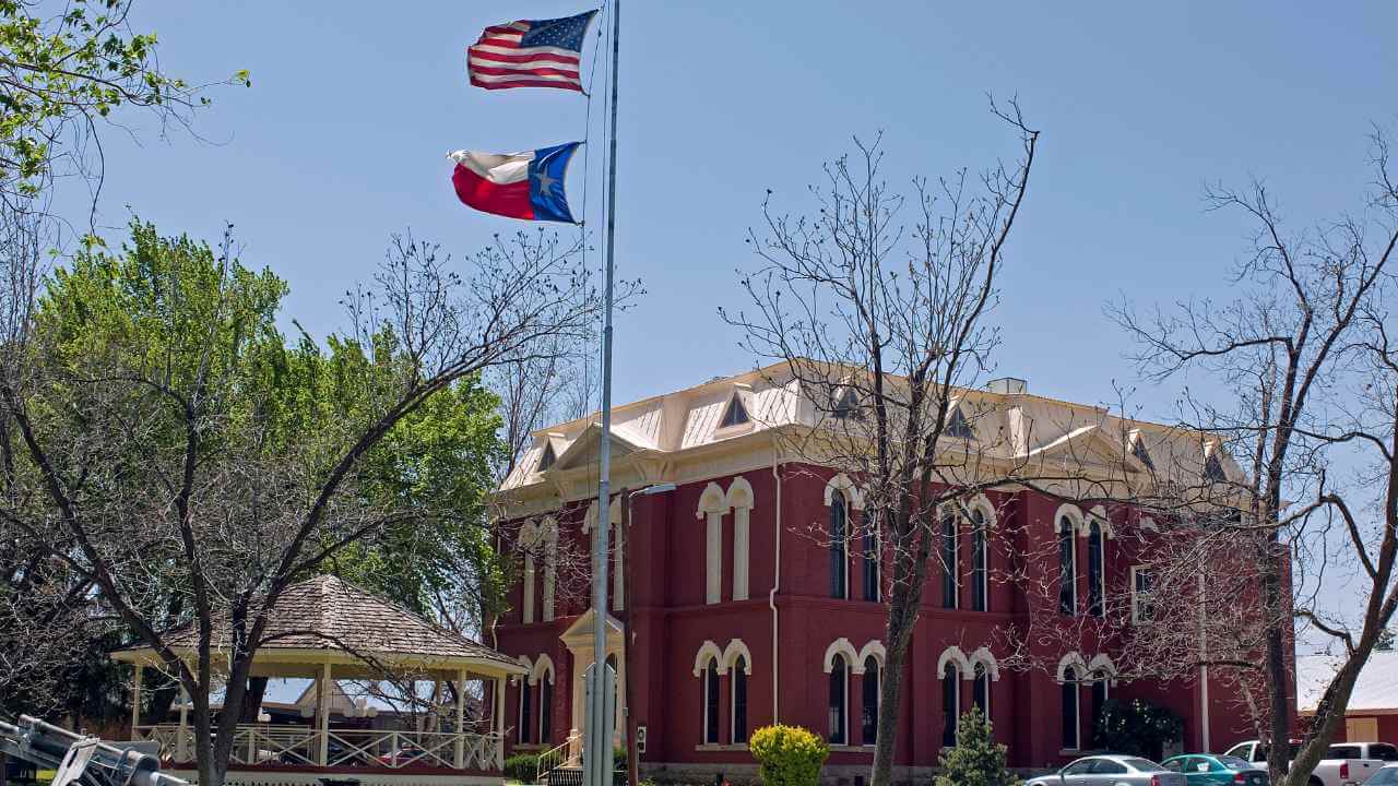 a red brick building with an american flag flying in front of it