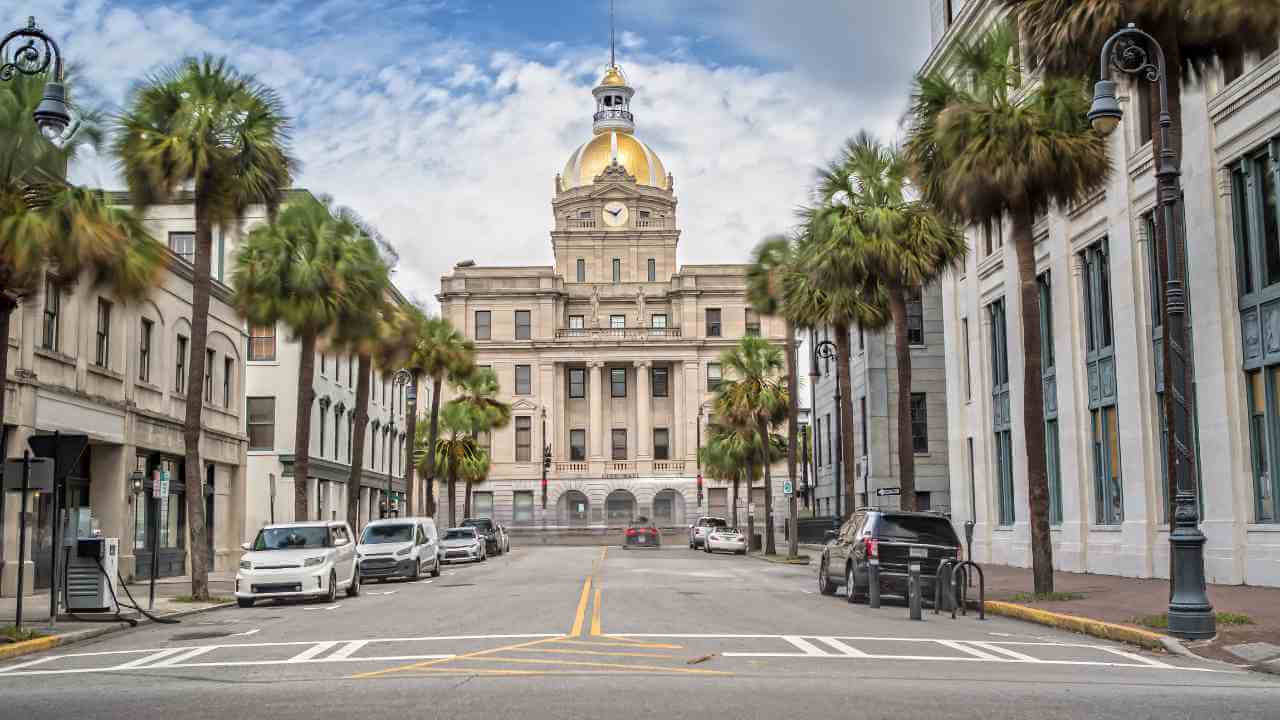 a city street with palm trees and a clock tower