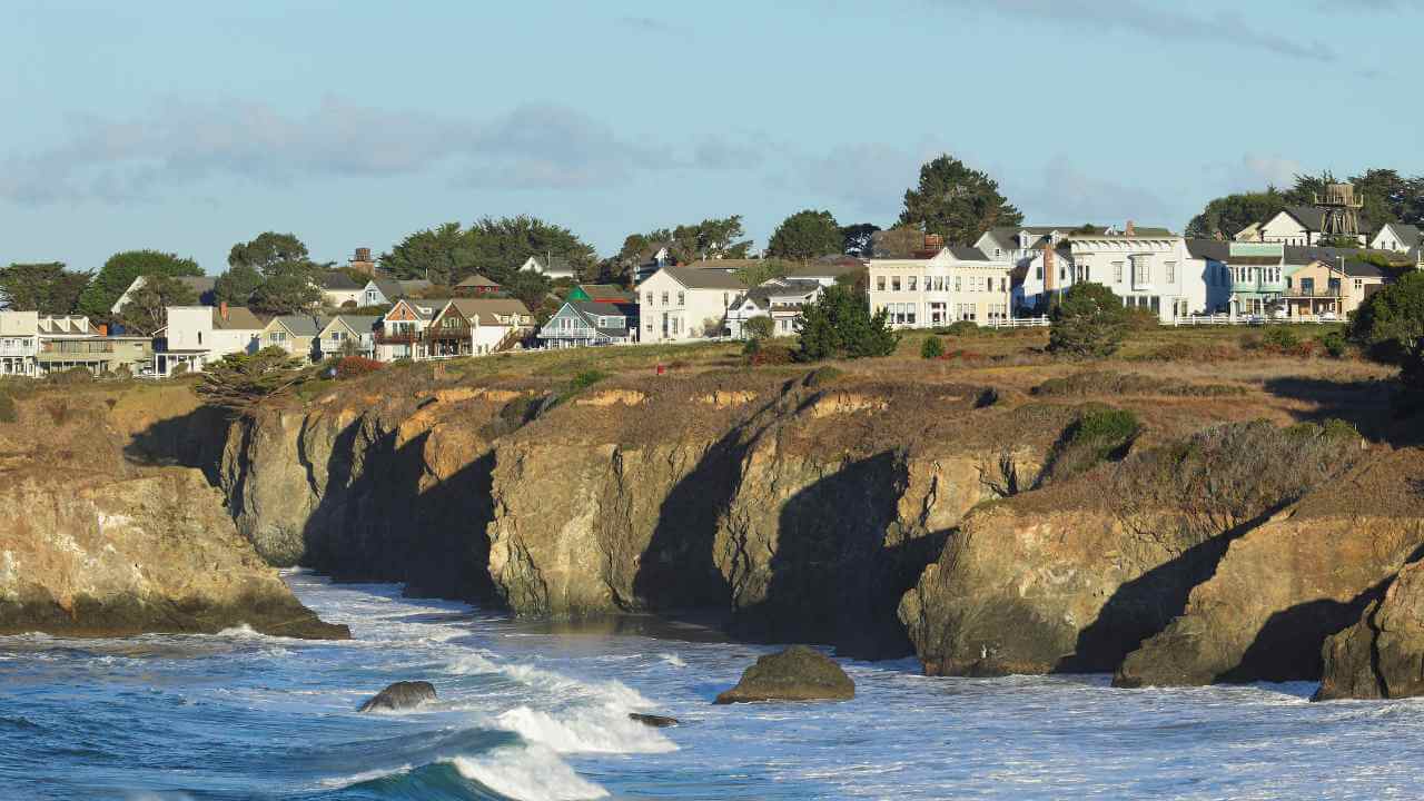 a view of houses on a cliff overlooking the ocean