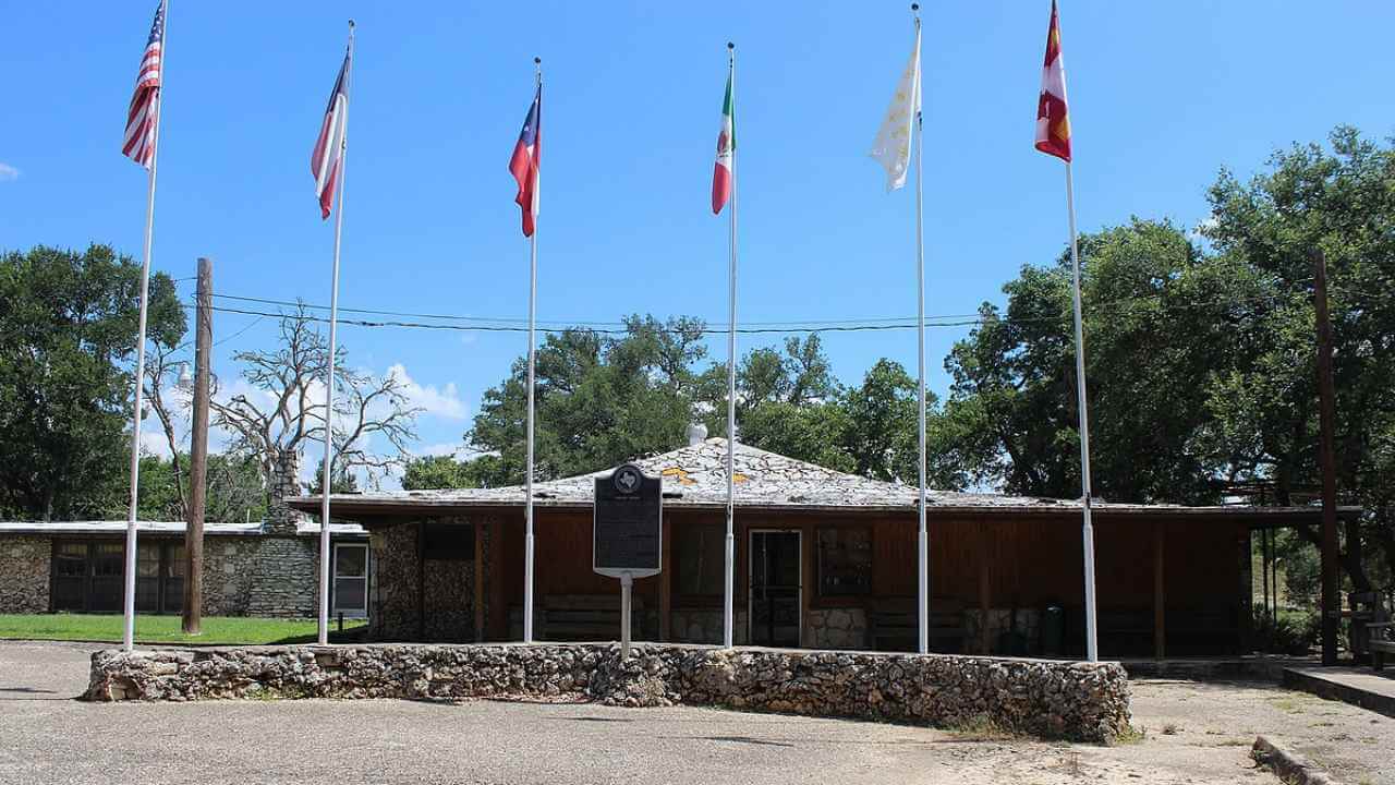 a stone building with flags flying in front of it