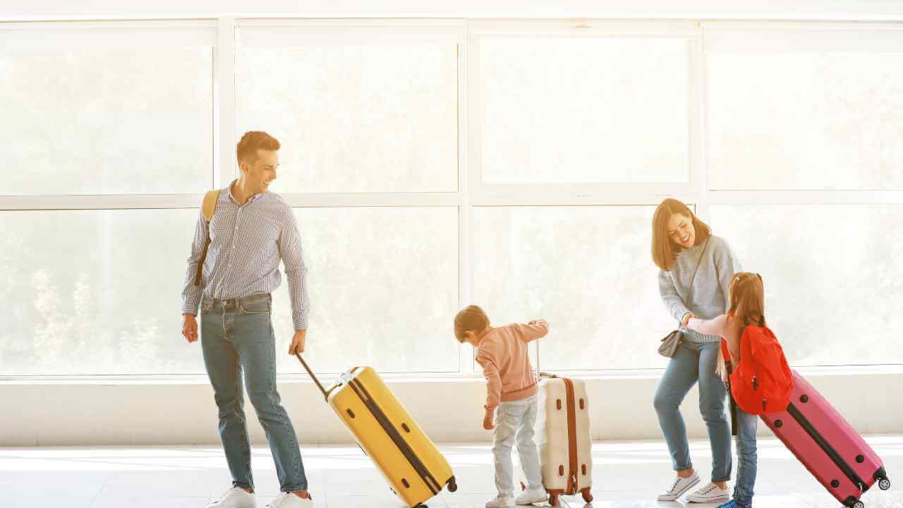 a family with luggage walking through an airport