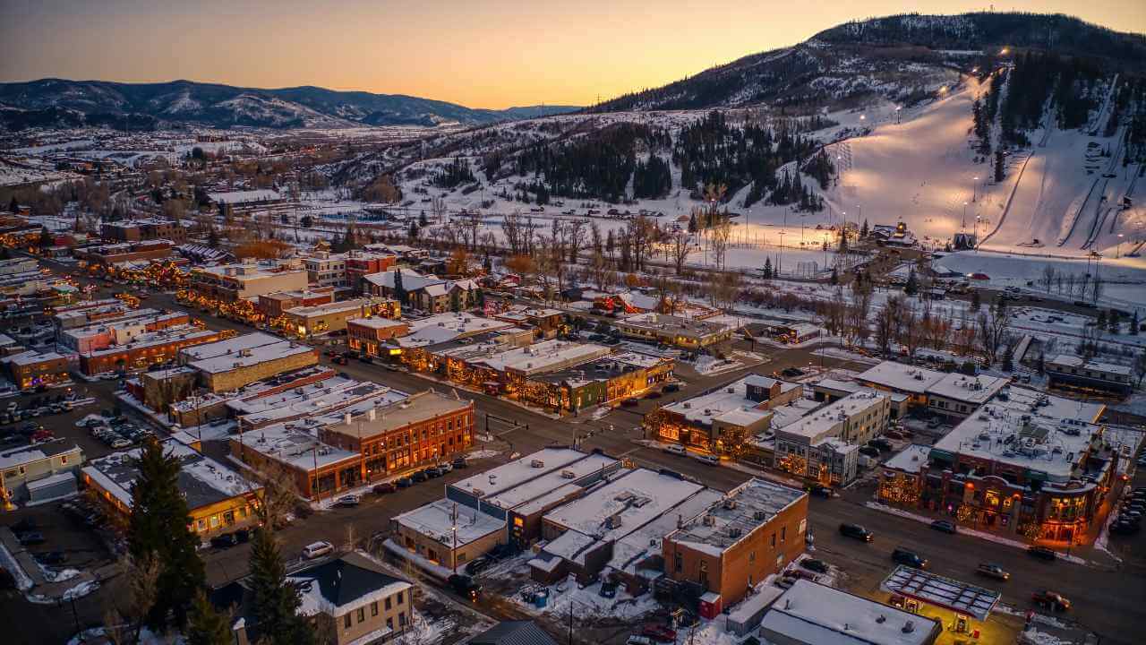 an aerial view of a snowy town at sunset
