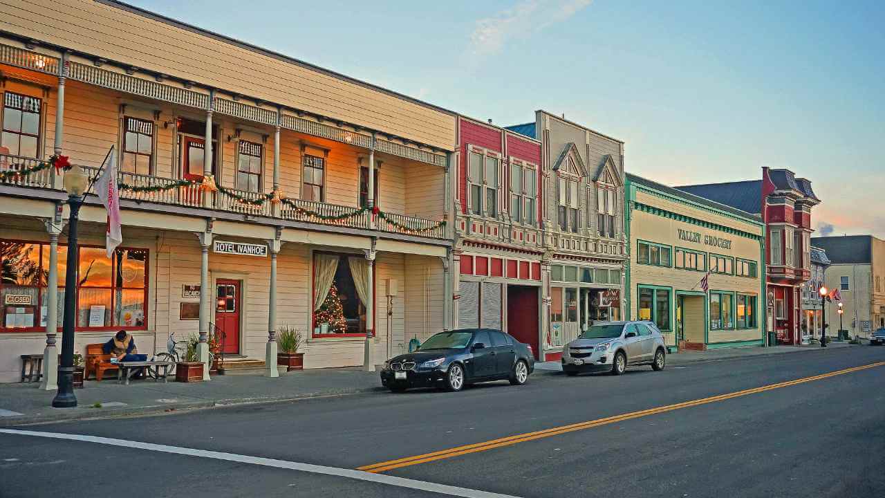 an old town with cars parked on the side of the road