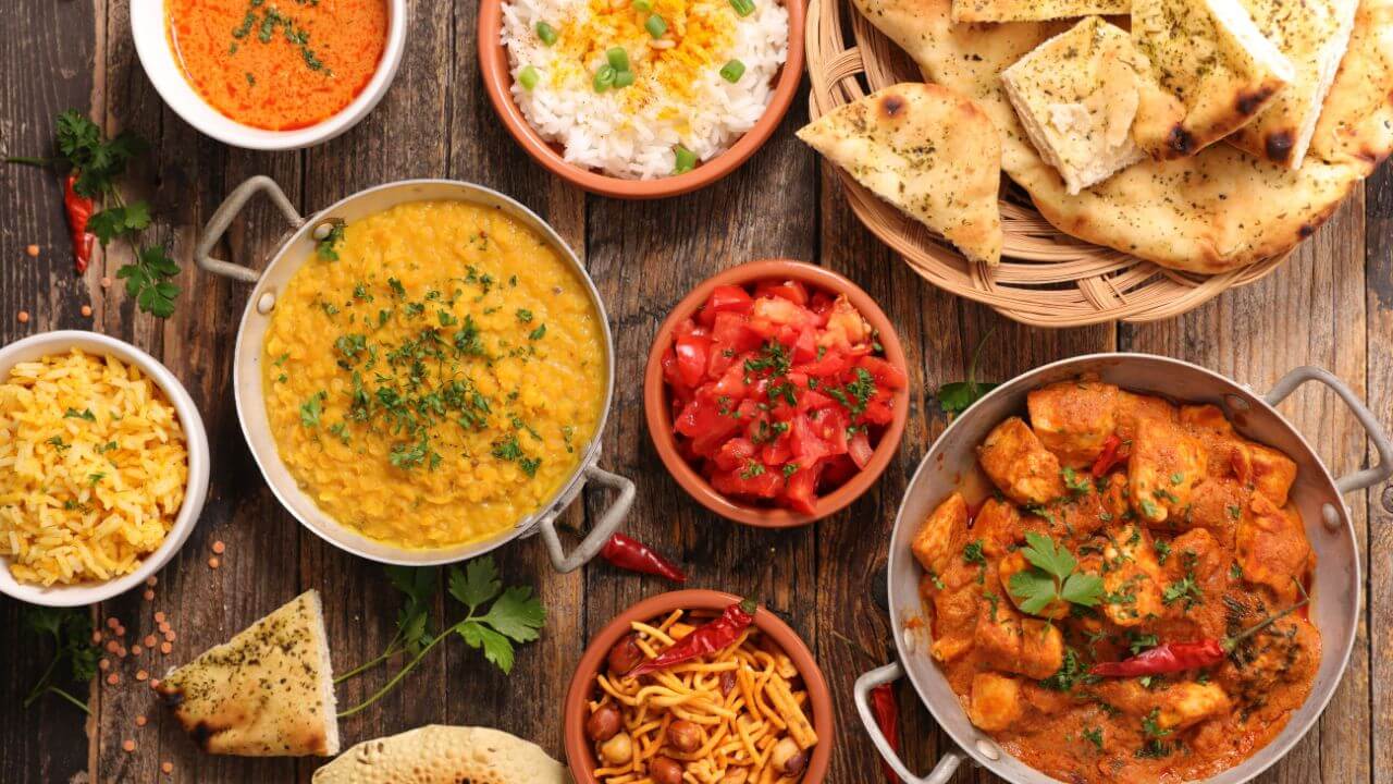 various dishes of indian food on a wooden table