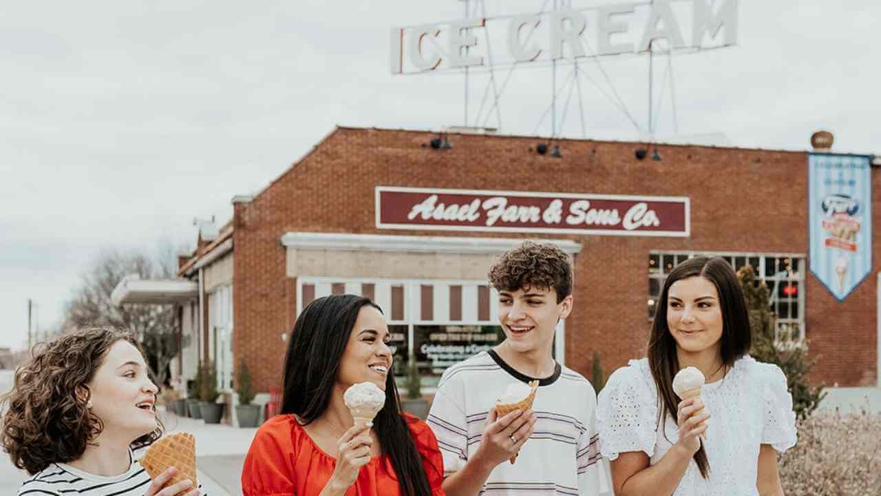 four individuals standing in front of an ice cream shop