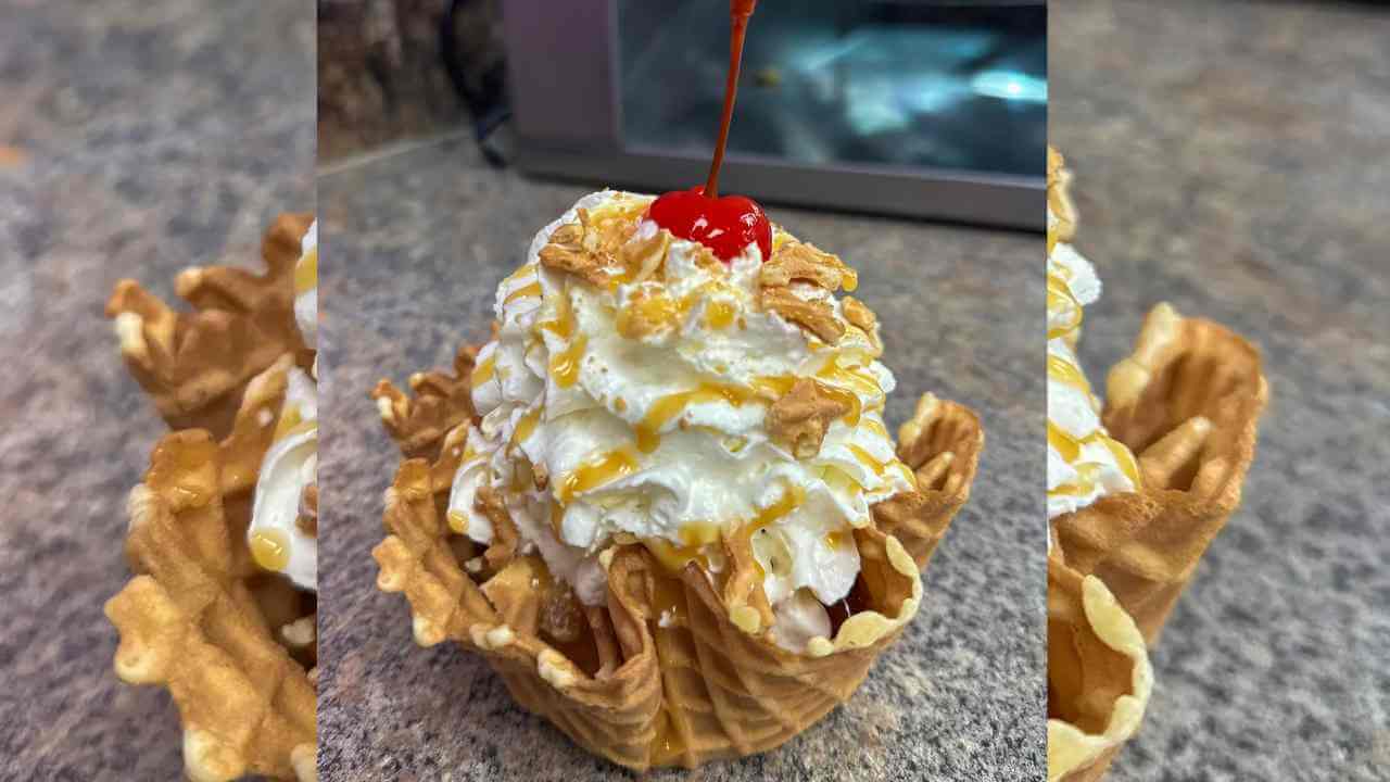 an ice cream cone with whipped cream and a cherry on top