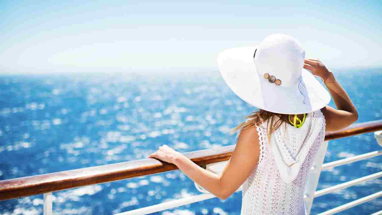 a person in a white hat looking out over the ocean
