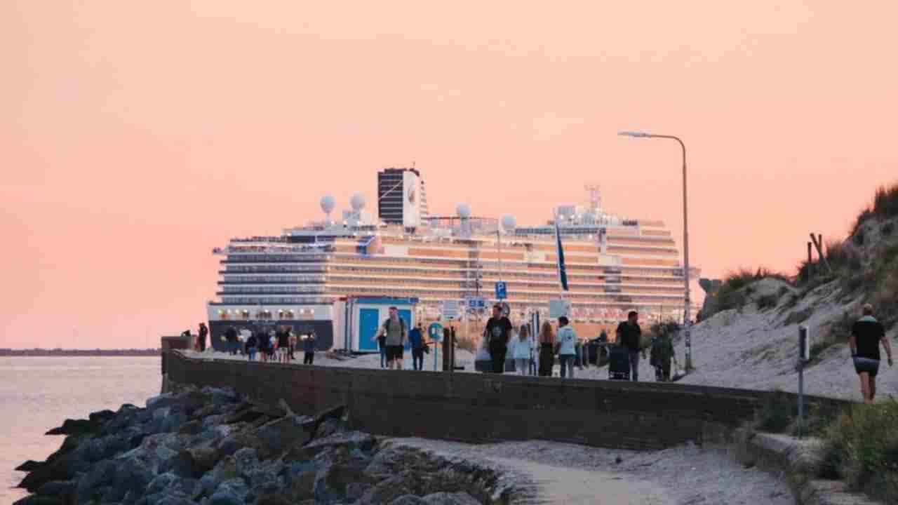 a cruise ship is docked on the beach at sunset