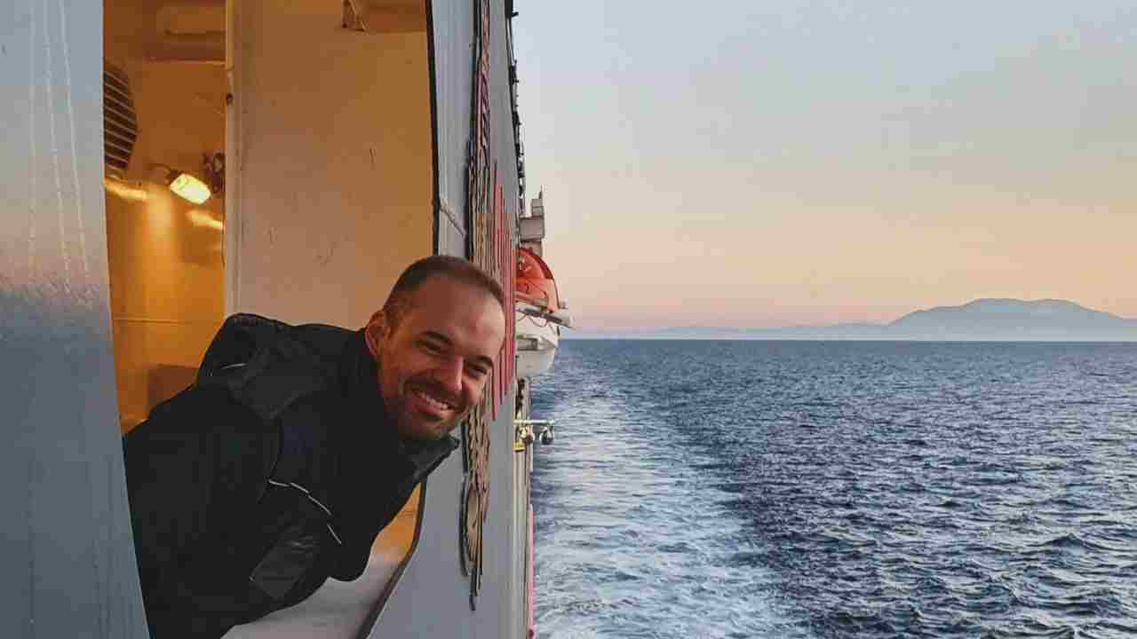 a person smiles from the window of a cruise ship